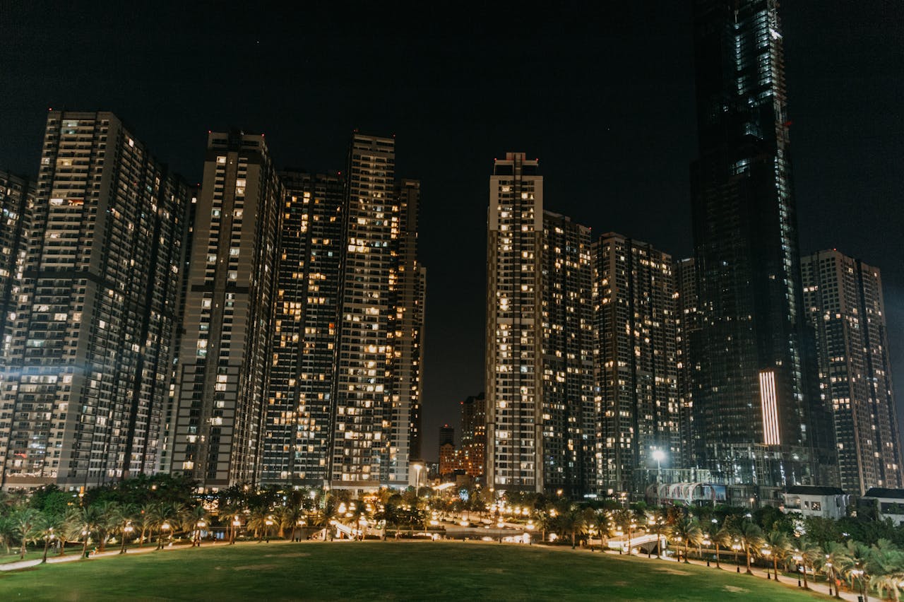 A vibrant night cityscape featuring modern skyscrapers illuminated against the night sky.