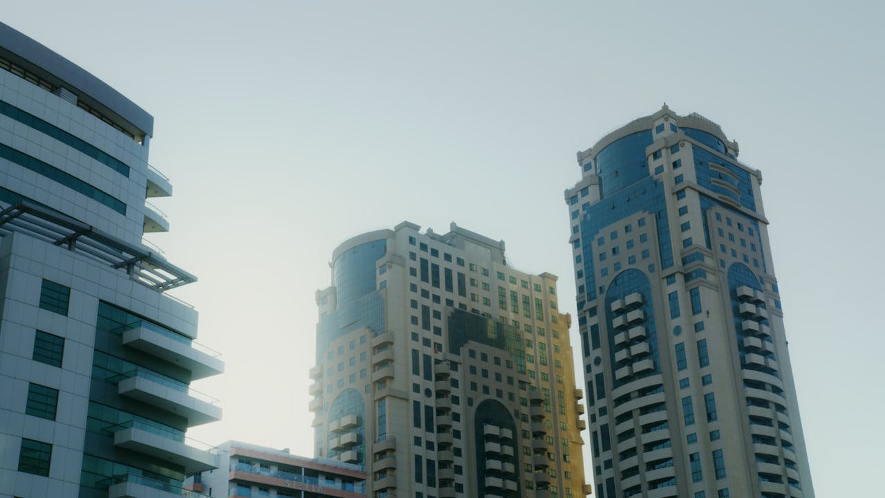 why-choose-us Low angle view of modern high-rise buildings under clear sky in Dubai, showcasing architectural elegance.